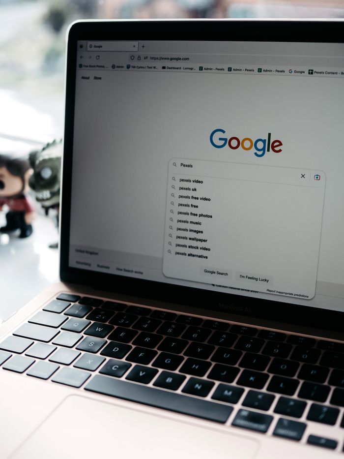 A close-up shot of a laptop displaying a Google search page with related searches visible.